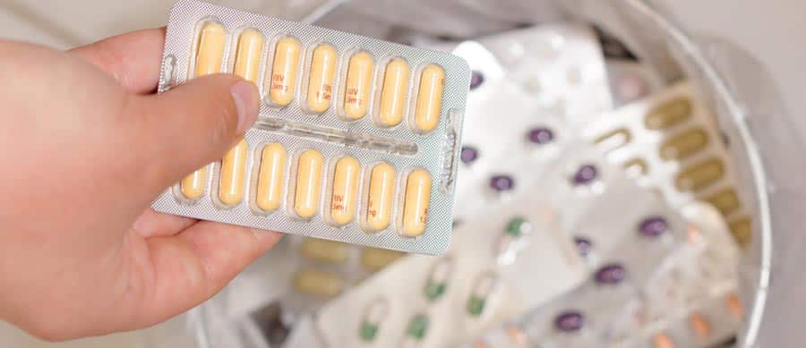 A hand holding a blister pack of pills symbolic of abrupt drug cessation (cold turkey), withdrawal, and the risks of detoxing without medical support.